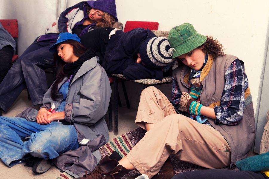Young homeless people sleeping in a basement